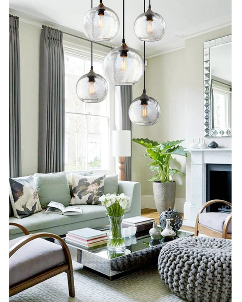 Living room with four hand blown glass pendant lights over kitchen island with seeded bubbles globe lamp, clear 8.7 inch diameter.