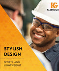 Antifog Safety Glasses Built For The Daily Grind Full Case Bulk Pack With Crystal Clear Lenses And Flexible Metallic Blue Frames For Rock Solid Job Site Reliability worn by a smiling worker in a safety helmet.