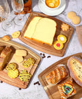 Three acacia wood cutting boards (8x10 in) arranged as serving trays with bread, cheese, and pastries.
