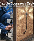 Person using Two-Way Articulating Borescope With Light USB-C Endoscope Inspection Camera through wooden panel hole.