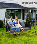 5 Foot Outdoor Porch Swing For Adults Wicker 3 Person Patio Swing With Cushions and Pillow in backyard with two people.
