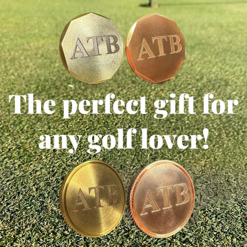 Personalized Golf Ball Marker Set Of 2 In Solid Brass And Copper With Knurled Edges Engrave Up To 20 Characters Durable American Made Metal Perfect Golf Gifts For Men Customizable Ball Markers For Serious Players shown on grass with 'ATB' engraving.