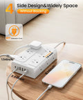Massive Heavy Duty Surge Protector Power Strip With Twelve Roomy Outlets And Six Fast Charge USB Ports Featuring An Insanely Slim Flat Plug Cable And Zero Tangle Design Perfect For Bedroom Couch Setup on a wooden table next to a smartphone.