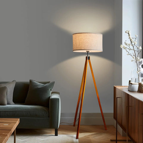 Eden Tripod Floor Lamp Dimmable LED With Solid Wood Legs in modern living room setting, tall tree style lamp next to sofa.