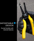 Gloved hand holding Reflex Super NM Cable Stripper For 12/2 And 14/2 Solid NM Wire with yellow textured grip handles