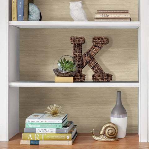 Bookshelf with Cream Tibetan Faux Grasscloth Peel And Stick Wallpaper, showcasing a neutral textured grasscloth look behind decor items.