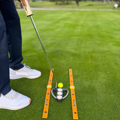 Pocket Size Golf Alignment Sticks And Swing Aid With Modular Ruler System in use on green grass for accurate putting practice.