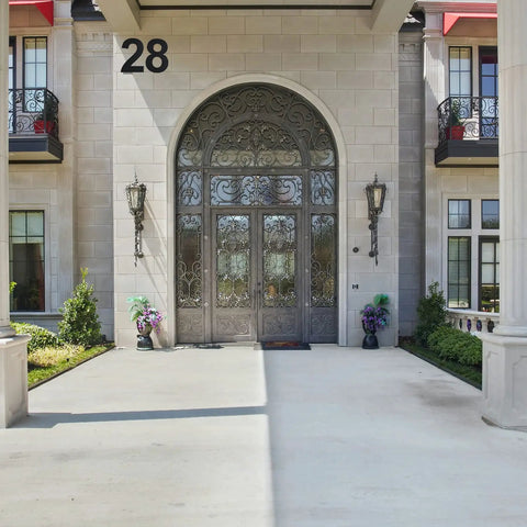 Modern entrance of a house with outdoor address number 28, decorative door, and plants, showcasing exterior architectural design.