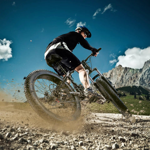 Cyclist riding 26 Inch Fat Tire Mountain Bike With 21 Speed Drivetrain, Dual Disc Brakes, Front Suspension on rough trail