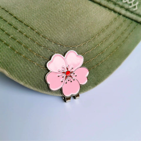 Magnetic Golf Ball Marker Set With Flower Crystal Markers And Hat Clip showing pink flower marker on green hat