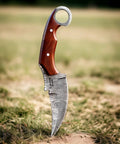 Handmade Damascus Steel Curved Fixed Blade Hunting Knife Nine Inch With Wooden Handle Ring Pommel Leather Sheath in grass