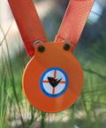 Close-up of Mini Gong Steel Shooting Target For.22 caliber with stand in the grass, showing durable powder coated steel plate.