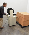 Operator using Heavy Duty Semi Automatic Pallet Strapping Machine Steel Probe Frame 23 X 31.5 X 55 Inches 175 Lb Tension with boxes.