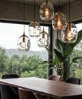 Dope Clear Art Glass Pendant Lights 2 Pack For Kitchen Island And Dining Room Table with sleek brass gold hardware over dining table.