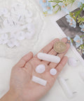 125 Piece White Tack In Drawer Glides Heavy Duty Furniture Slider Repair Kit For Dressers Solid Plastic And Iron Construction with a coin for size reference.