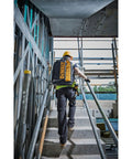 Massive 40 Liter Tool Backpack Built Tough As Nails For Contractors being carried up stairs on a construction site.
