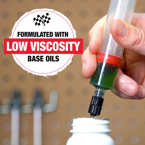 Bicycle Hydraulic Disc Brake Fluid Mineral Oil Low Viscosity For Crisp Lever Feel Smooth Pad Retraction And Consistent Stopping Power Long Lasting 16 Ounce Bottle being poured into a white container, hand holding the bottle with low viscosity text in background.