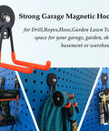 Magnetic Power Tool Organizer For Garage And Workshop with rubber-coated hooks holding drill, hose, and tools on pegboard.