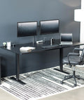 Vivo Black Standing Desk 71 By 36 Inches Electric Height Adjustable Sit Stand Workstation with dual monitors and ergonomic chair.