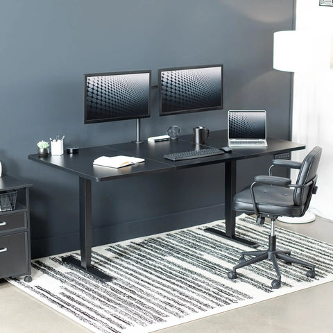Vivo Black Standing Desk 71 By 36 Inches Electric Height Adjustable Sit Stand Workstation with dual monitors and ergonomic chair.