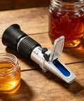 3 In 1 Honey Refractometer With ATC For Honey Maple Syrup And Molasses High Precision Sugar Tester Measuring Brix From 58 To 90 Percent Moisture From 12 To 27 Percent And Baume 38 To 43 For Beekeeping on wood table with honey jars