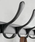 Close-up of Wall Mounted Coat Rack With Six Heavy Duty Hooks Stainless Steel Metal Hanger showing black finish and space for jackets.