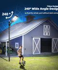 Ultra Bright Outdoor Solar Street Light With Dusk To Dawn Sensor illuminating a yard with 240° angle near a gray barn building.