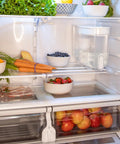 Refrigerator with 18 Cup Home Water Filter Dispenser That Really Cleans Water Removing Bacteria And Parasites Reducing Microplastics And Chemicals Like Lead Mercury PFAS Chlorine Herbicides Pesticides For Pure Great Tasting Tap Water Every Day next to fresh produce.