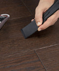 Your Go To Floor Repair Putty In Dark Brown Fast Curing Acrylic Wood Filler For Laminate Vinyl applied with a scraper on a wooden floor.