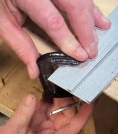 Swanson CG100 cutting guide, gray anodized aluminum with joiner bar; hands hold a black C-clamp.