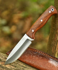 Full Tang Hunting Knife With 10 Inch Overall Length, high carbon steel blade, rosewood handle, and sheath resting on wood.