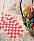 Race Car Themed Gift Bags With Handle Pack Of 50 Portable Lightweight Plastic Candy Bags next to a basket with chocolates and candies