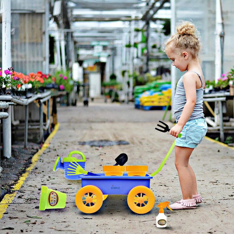 Child playing with Garden Wagon And Tools Toy Set For Kids 15 Pcs Outdoor Sand Beach Play Set Toddlers 1 3 in a greenhouse