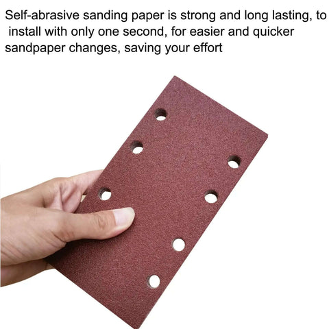 Hand holding a hook and loop sandpaper sheet with perforations, displaying texture and design, for 1/3 sheet sander pack with 60 80 100 120 150 and 240 grit aluminum oxide for woodworking metalworking and paint projects a versatile grit set for smoothing rough surfaces removing finish and tackling DIY renovations.