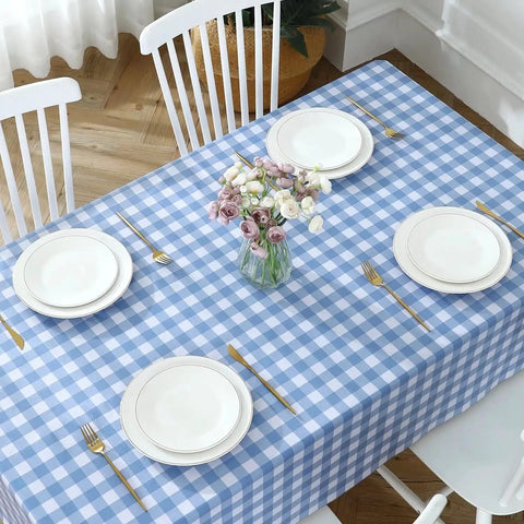 Buffalo Gingham Waterproof Vinyl Tablecloth Heavy Duty Wipeable Checkered Table Cover Outdoor Patio Picnic Camping 54 X 78 Inches Light Blue Spillproof PVC Protector with plates and flowers on top.