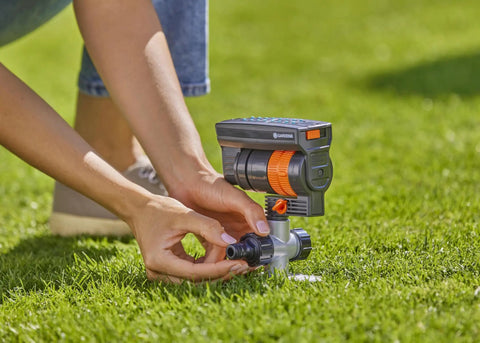 Person adjusting the ZoomMaxx Adjustable Oscillating Sprinkler On Metal Step Spike For Even Watering Of Large Lawns Up To 2300 Sq Ft