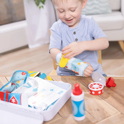 Child playing with Get Well First Aid Kit Play Set For Kids With 25 Realistic Medical Tools For Pretend Doctor Play, bandage visible.