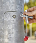 Hand holding Handy Universal Control Cabinet Key for Gas, Water, and Electric Shutoff Systems with Slot 10x7 Bit, Phillips PH2, near valve