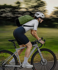 Cyclist with a green Lightweight Waterproof Dry Bag With Front Zip Pocket 10L Roll Top Closure for Travel Kayaking and Beach Days