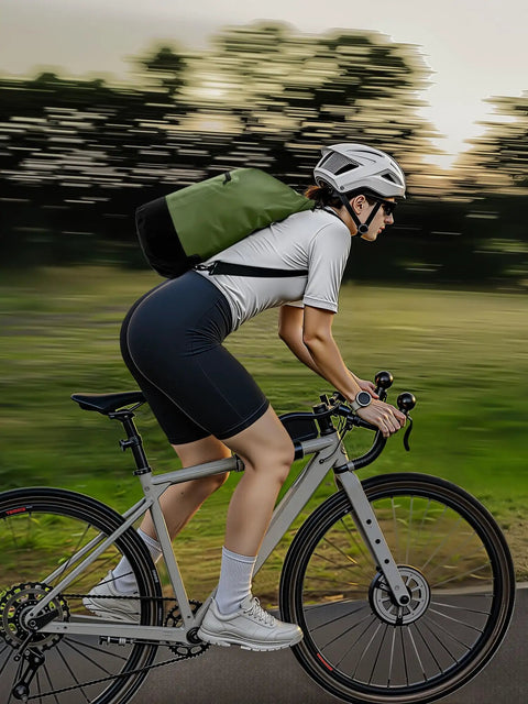 Cyclist with a green Lightweight Waterproof Dry Bag With Front Zip Pocket 10L Roll Top Closure for Travel Kayaking and Beach Days