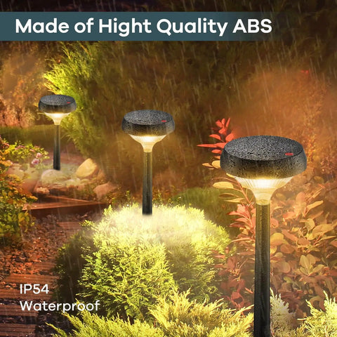 Solar Pathway Lights 4 Pack Outdoor Waterproof Warm White Nighttime Glow With Auto On Off Sensor illuminating a garden path.