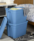 Straight Up Beast Mode 18 Gallon Plastic Storage Bin With Secure Snap On Lid Stackable Heavy Duty Moving Container For Workshop Home Office Or Backyard Shed Blue with clothes in a bedroom.