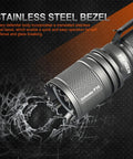 Close-up of Defender P16 Tactical Flashlight with crenelated stainless steel bezel on a textured background.