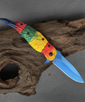 Colorful Parrot Pattern Folding Pocket Knife With Gradient Parrot-Scale Handle, 3-Inch Blue Coated Blade on wood surface