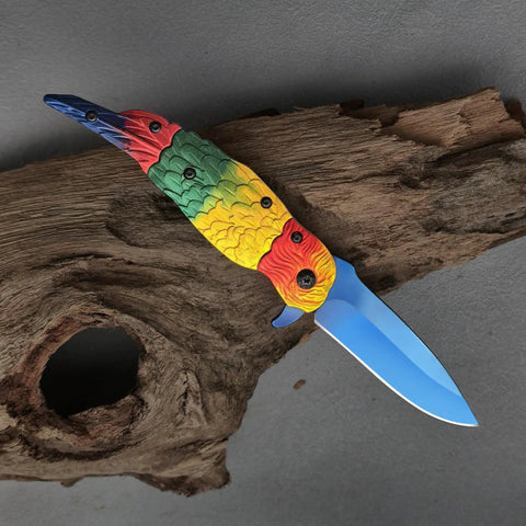 Colorful Parrot Pattern Folding Pocket Knife With Gradient Parrot-Scale Handle, 3-Inch Blue Coated Blade on wood surface