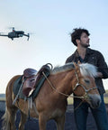 Mavic 2 Pro Drone Quadcopter With Hasselblad Camera flies near man with horse outdoors