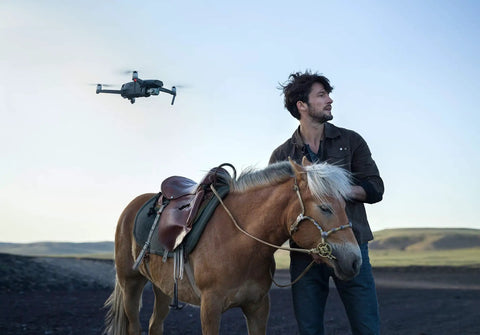 Mavic 2 Pro Drone Quadcopter With Hasselblad Camera flies near man with horse outdoors