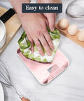Cleaning a pink Slim Digital Kitchen Scale With 11Lb Capacity, 304 stainless steel surface, easy to clean feature.