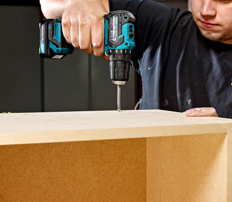 Badass 12v Max Lithium Ion Cxt Brushless Drill Driver Featuring Electric Brake And Bright Led Lamp Keyless Chuck Compact Heavy Duty Cordless Tool Built Different For Real World Projects in use drilling a wood surface.