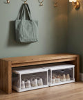 Clear Stackable Storage Bins With Transparent Slide Front Doors organizing shoes under a wooden bench in a room.
